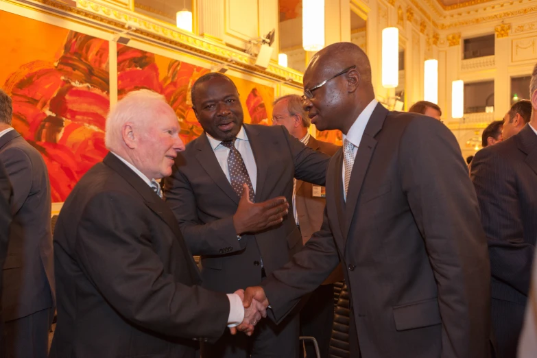 a group of business men shaking hands in a room