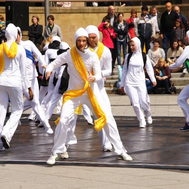 several people dressed in all white performing a dance