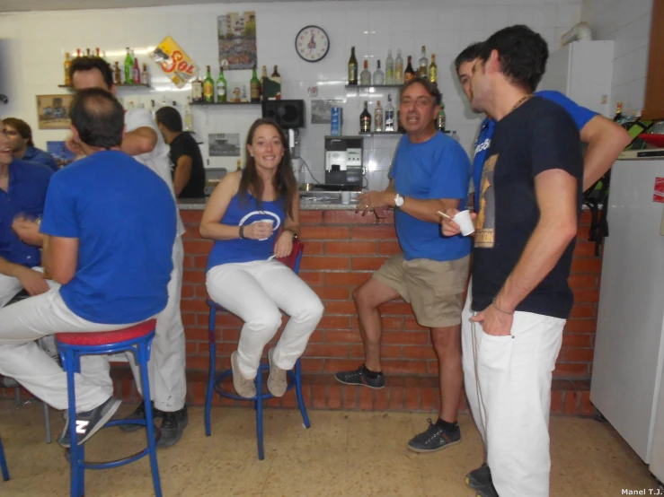 several people are talking in a small kitchen