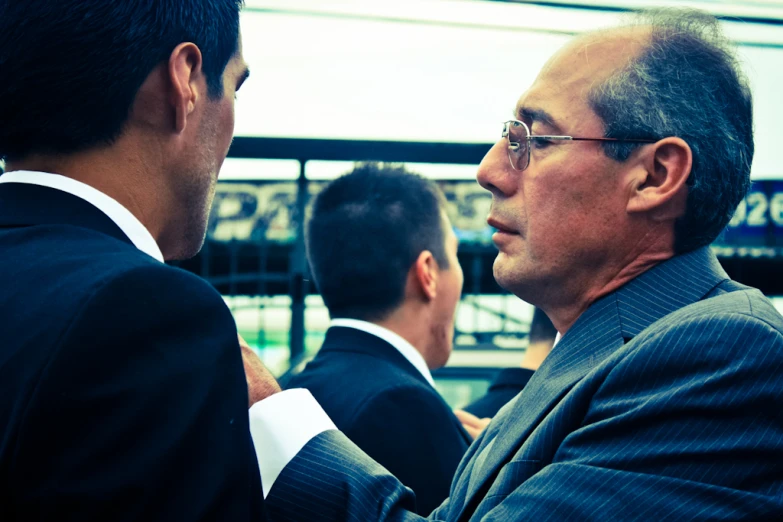 a man in a blue suit is talking to another man