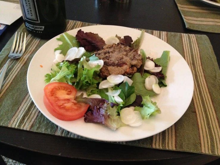 a white plate topped with salad on top of a table