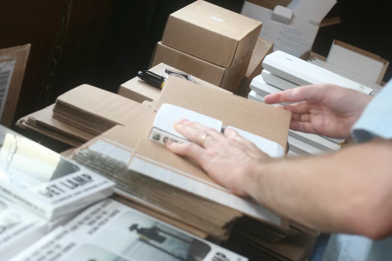 a person's hand placing mail into a box