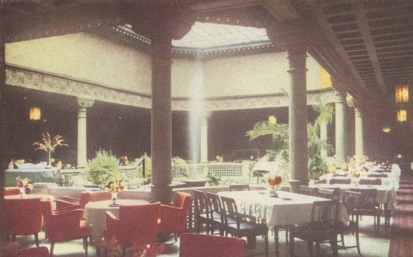 a restaurant interior with large tables and red chairs
