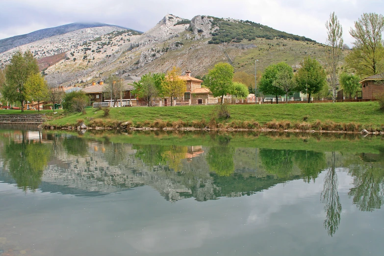 water with house on it and mountain range in background