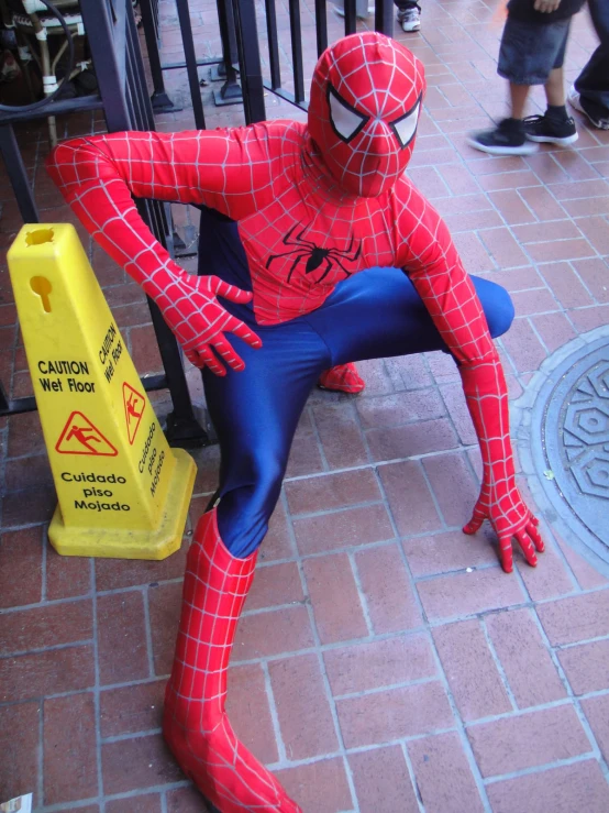 a man sitting on a street bench next to a yellow warning sign