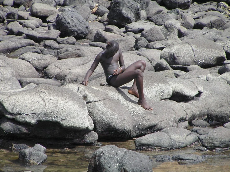  man in his underwear relaxing on rocks