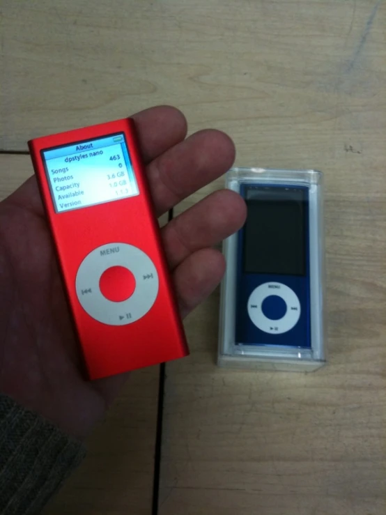 someone is holding a red ipod in a small case