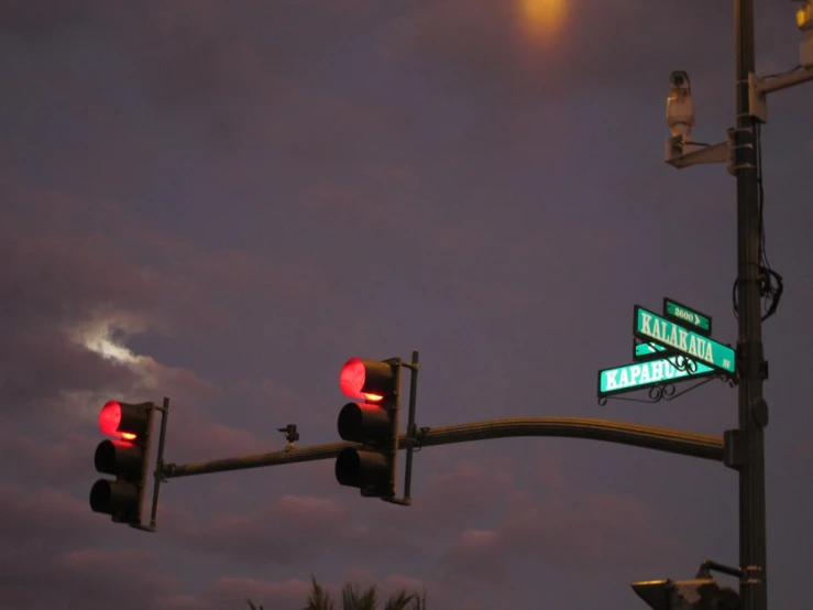 two green street signs under a dark sky