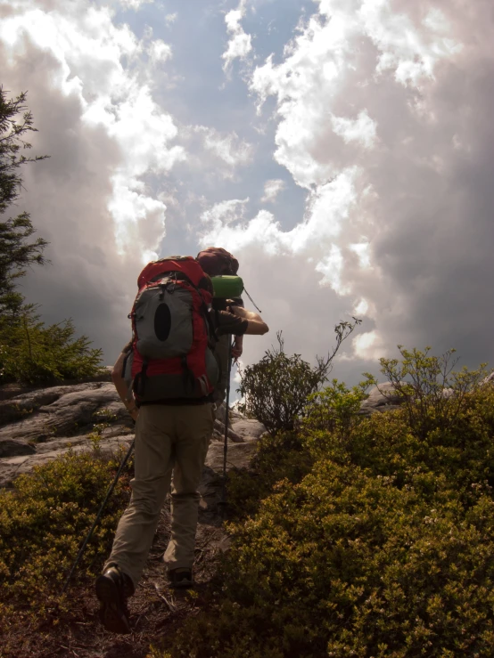 a man with a backpack climbing up a mountain