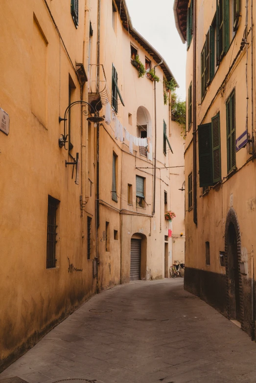 a narrow alley way that has some green shutters