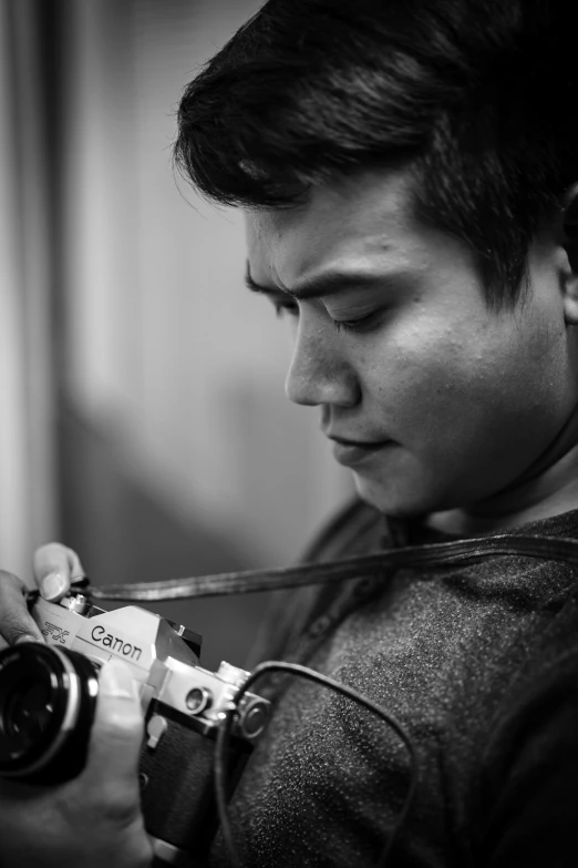 a black and white image of a man holding a camera