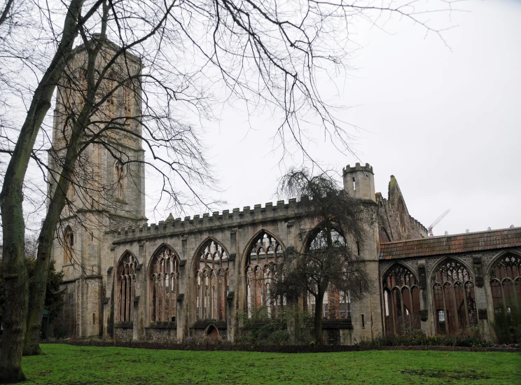 an old abandoned cathedral in a field with grass and trees