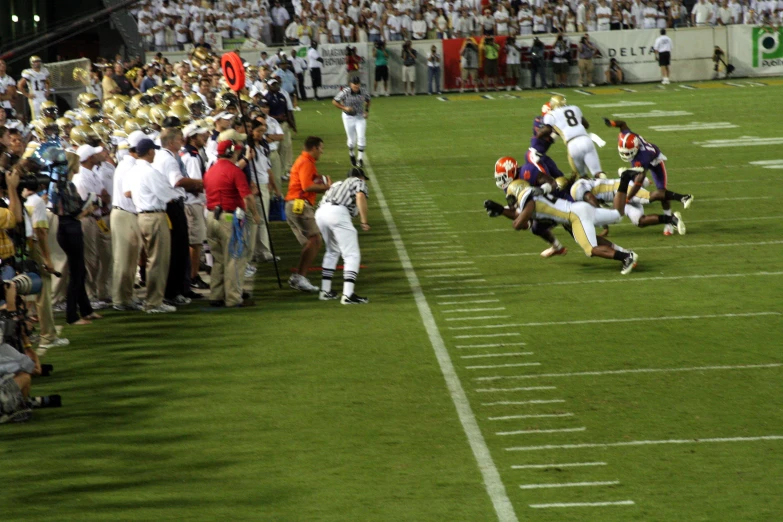 a football player leaps over another player to grab the ball