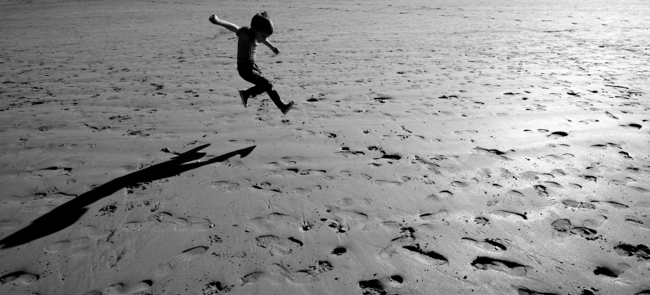 the person is running on a beach holding an umbrella