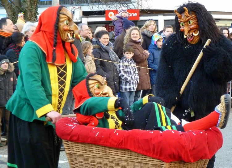 two people in costumes standing with a large  dog in the street