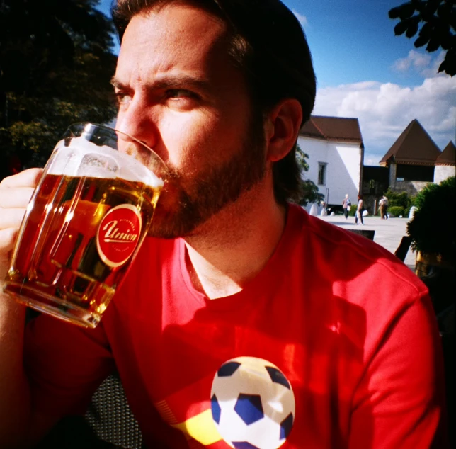 a man in red shirt drinking from a glass