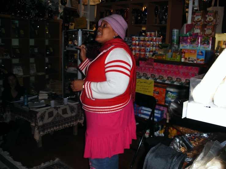 a woman wearing red and white sweater standing in a store