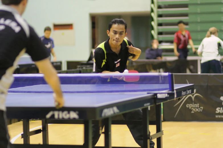the young people are playing table tennis on the court