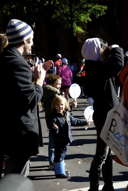 the small child is holding some white balloons