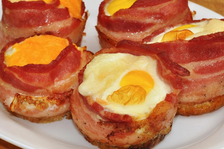 bacon wrapped breakfast foods arranged on a plate