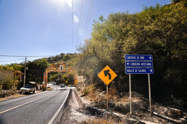 road signs near a street under a bridge