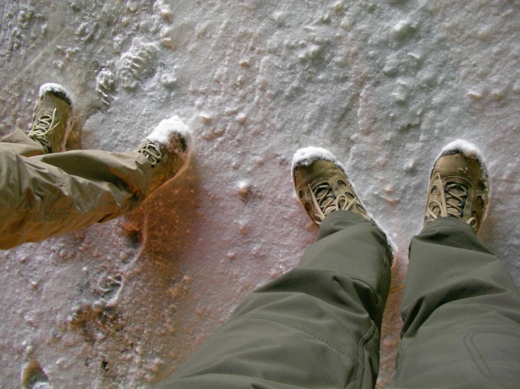 person standing on the ground with their feet in the snow