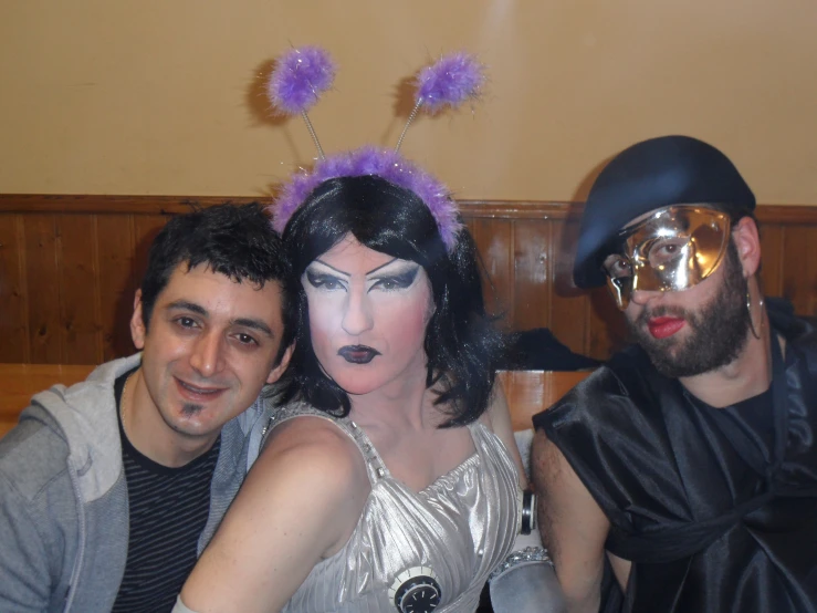 three people wearing masks pose for a po