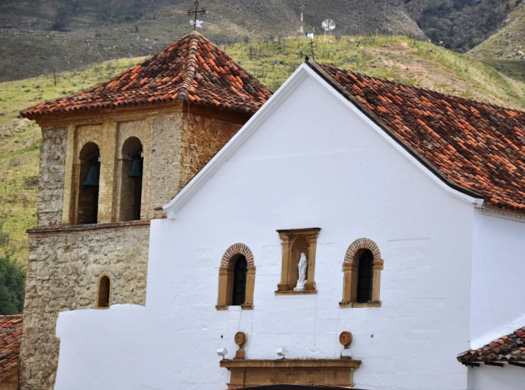 a building with three windows that are in front of some hills