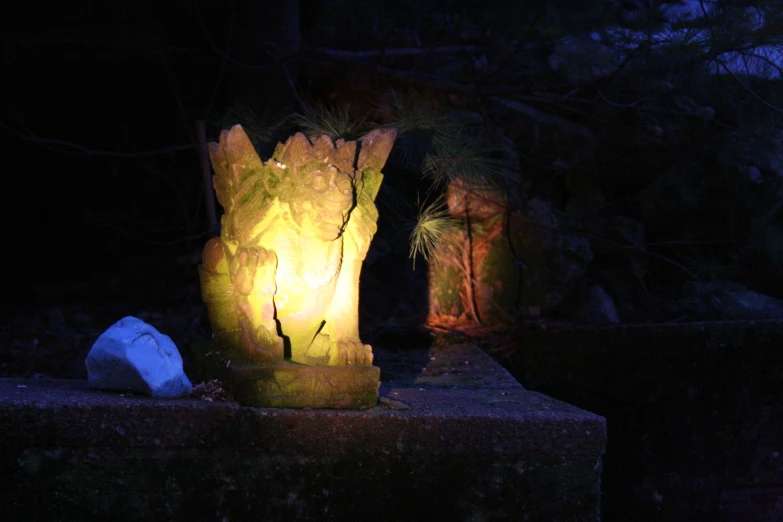 an outside area with candles and plants lit up at night