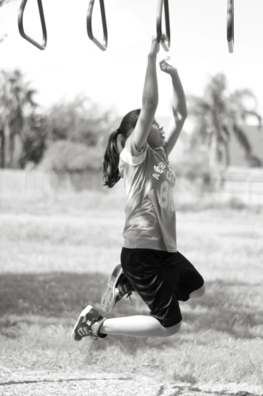 a girl swinging on a pair of swing sets