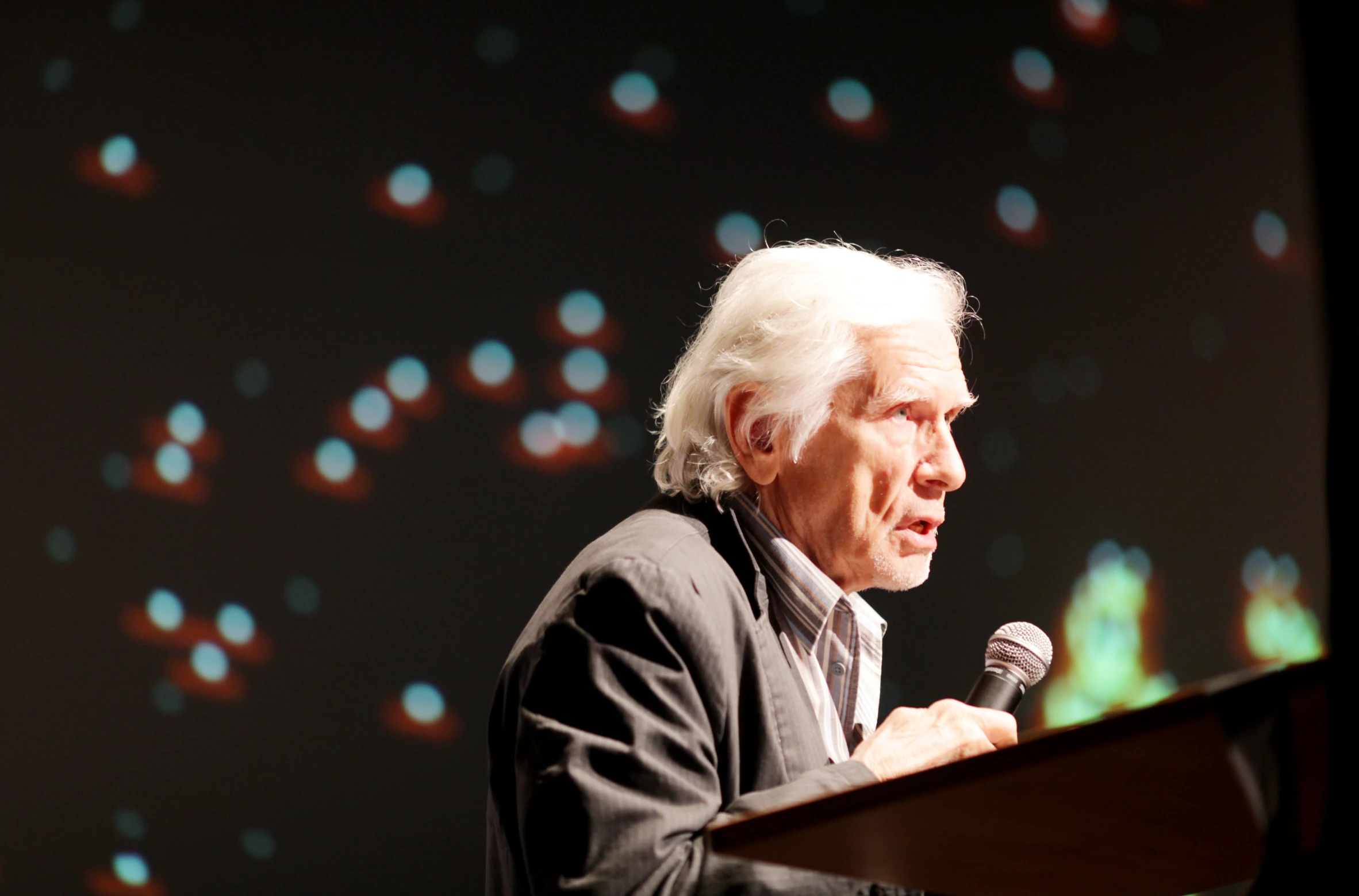 a man is speaking while holding a microphone