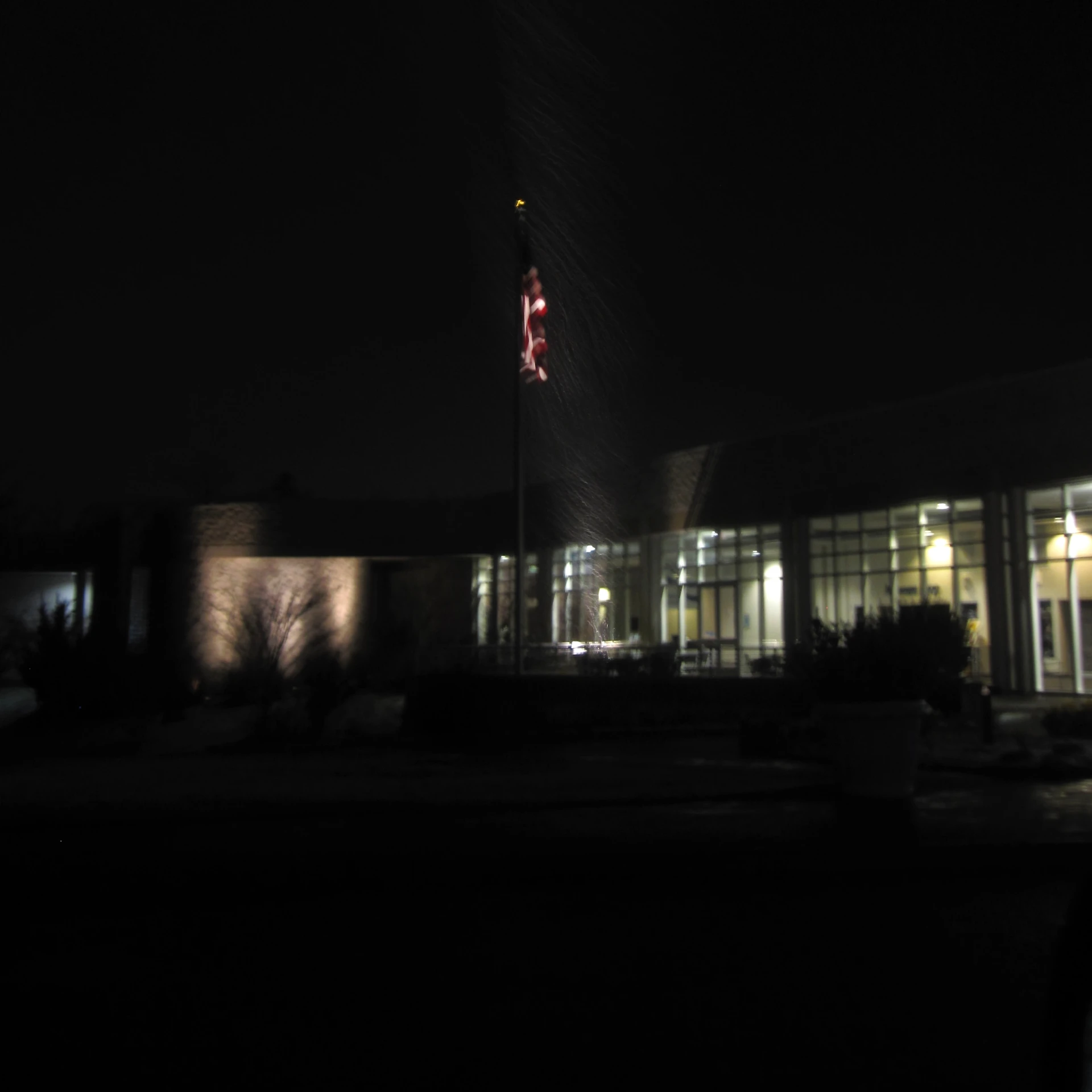 a building at night with the clock and lighted lights on