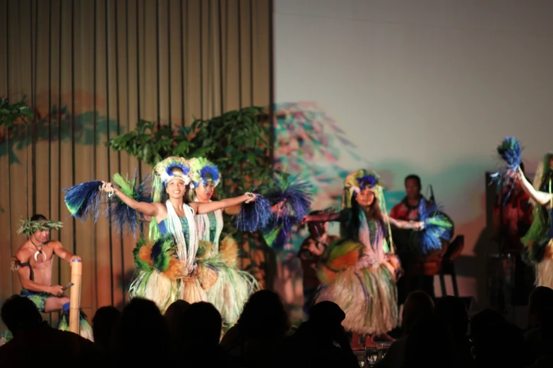 a number of performers on stage in large outfits