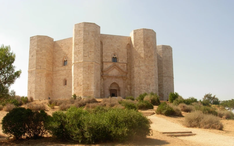 large stone castle sitting in the middle of a desert area