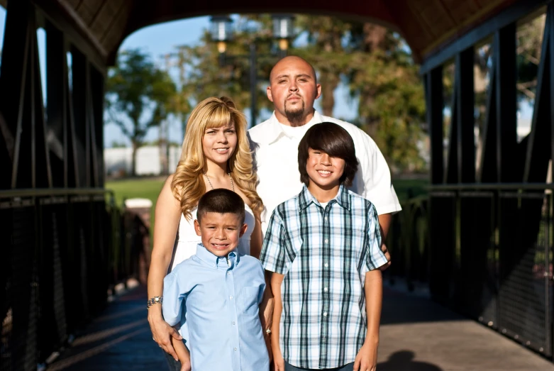 family posing for po under covered bridge on path