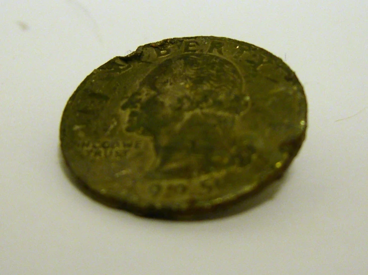 an antique bronze coin on a white surface