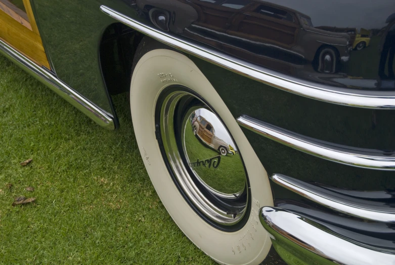 the wheel of an old car with chrome rims