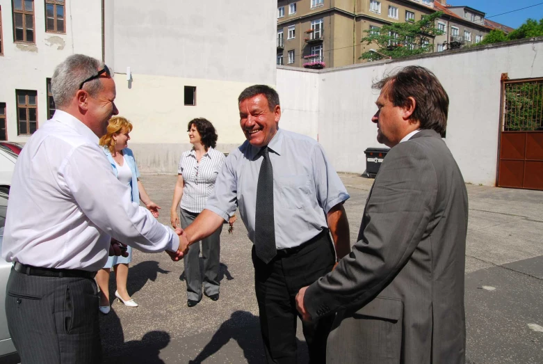 there are three men in suits shaking hands