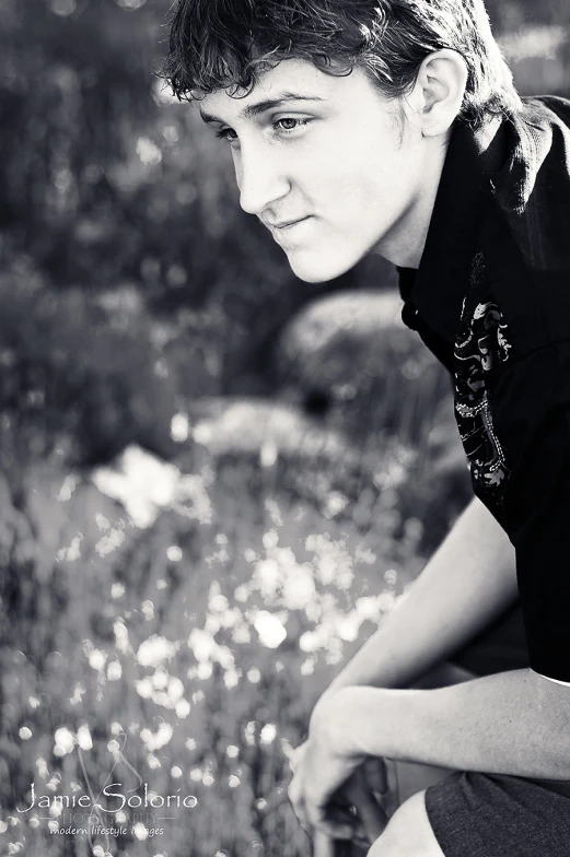 a young man is sitting in a field