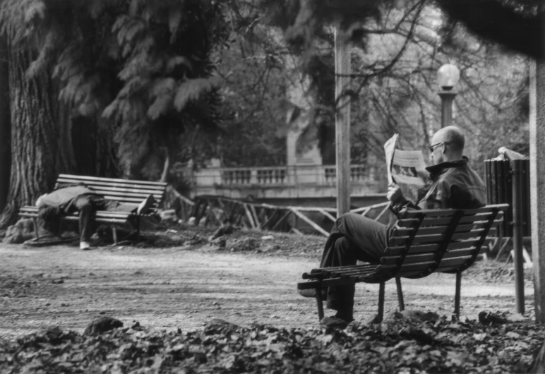 a person sitting on a bench reading a book