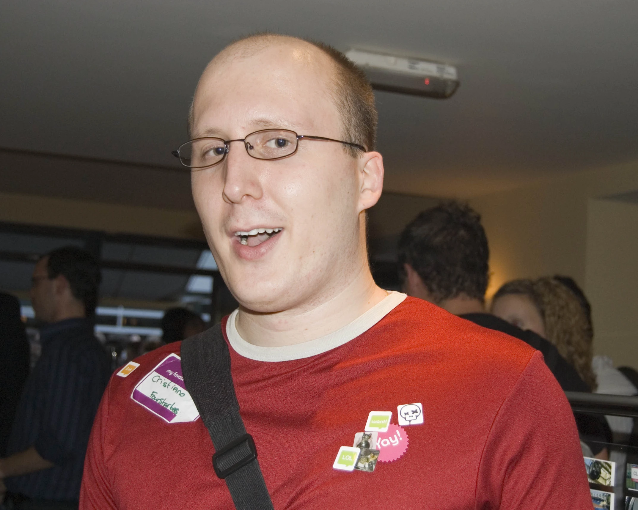 a smiling man with a patch in his chest