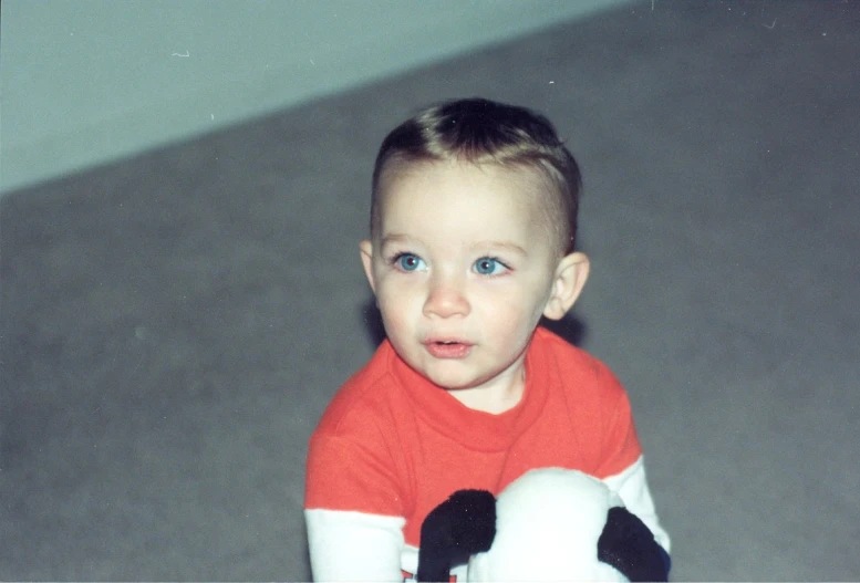 a small child with a stuffed toy is staring at the camera