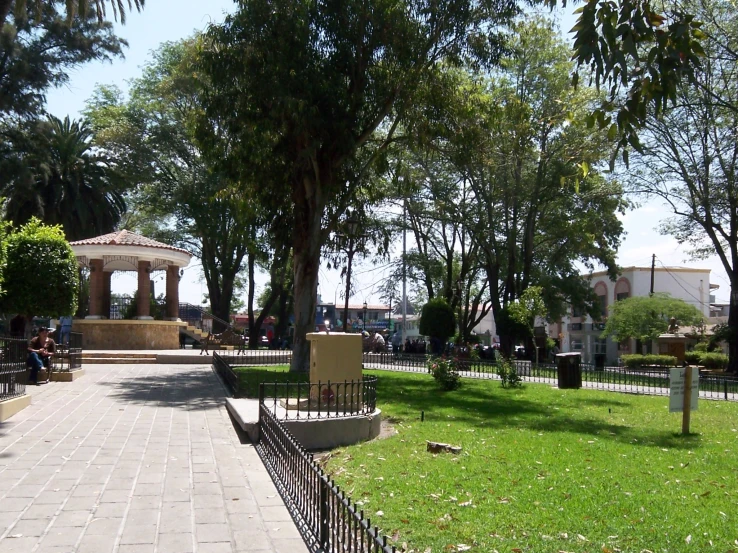 a beautiful park is surrounded by trees and benches