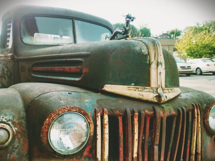 an old rusted truck with the front lights turned to see its headlight and headlights