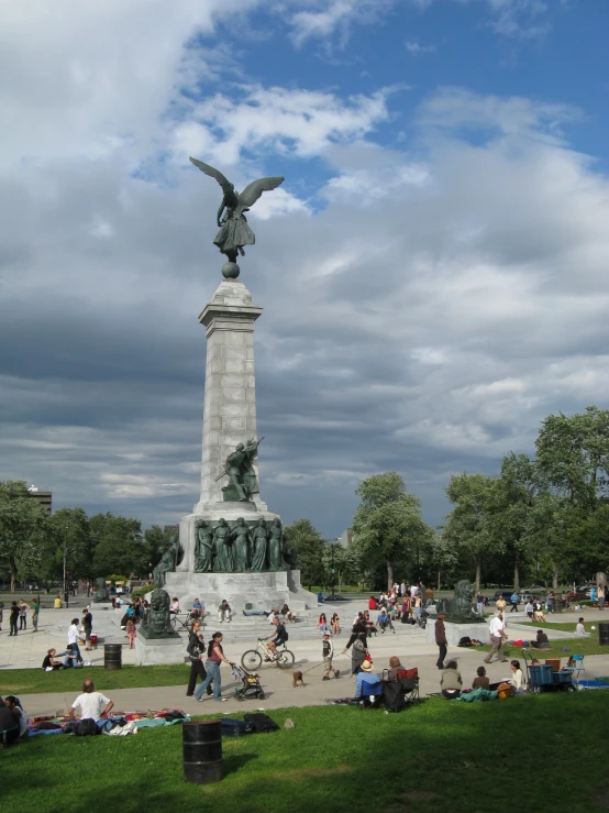 several people sitting near a sculpture in the park