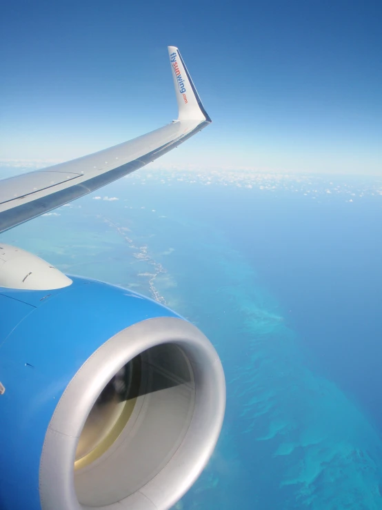 the view from the airplane window looking out at the ocean and land