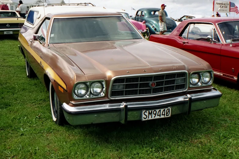 old cars parked in a field with green grass