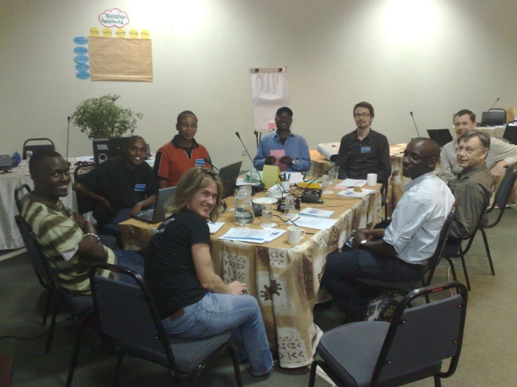 a group of people sitting around a long table