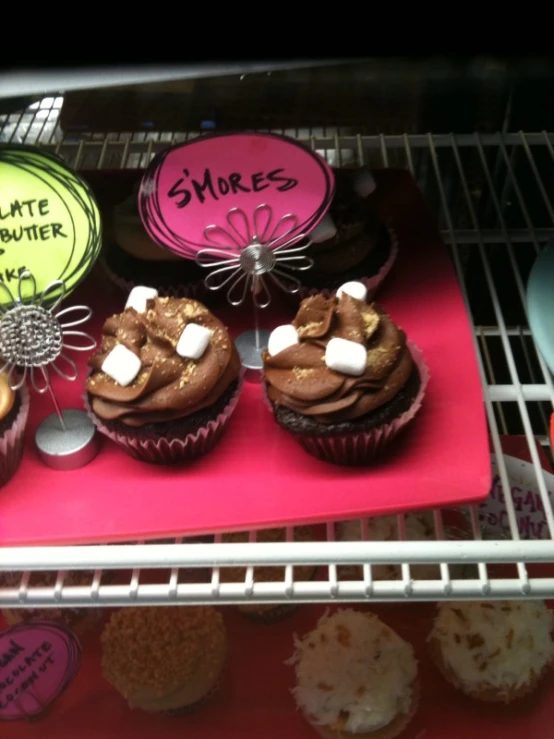 cup cakes on display in a bakery window