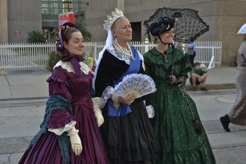 three ladies are dressed in colonial dress